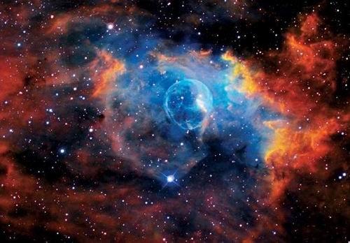這是著名的“氣泡星云”（Bubble Nebula），這是一個(gè)灰塵氣體星云，其直徑為10光年，相當(dāng)于60萬億英里。氣泡星云是由一顆恒星燃燒時(shí)的脫離物質(zhì)構(gòu)成，恒星燃燒時(shí)可釋放出太陽數(shù)百倍亮度的光芒。該星云距離地球11000光年，位于仙后星座。