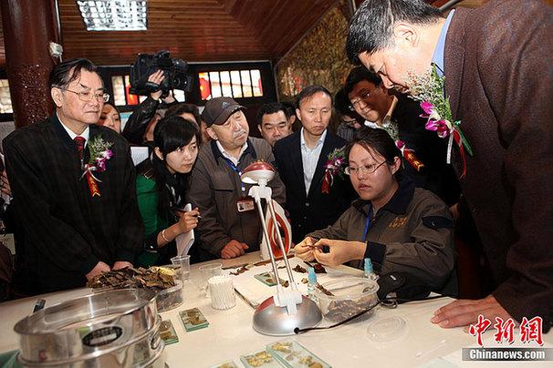 重慶大足石刻千手觀音搶救性維修保護(hù)工程現(xiàn)場，國家文物局局長單霽翔（右一）現(xiàn)場了解舊金箔的處理程序。
