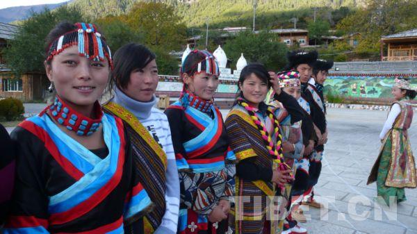 民俗村門口迎接來(lái)客的藏族姑娘和小伙