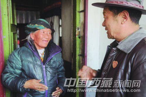 在黨的群眾路線教育實踐活動中，拉薩市城關(guān)區(qū)丹杰林社區(qū)民意組長、66歲的老黨員索朗積極為社區(qū)群眾辦實事，做好事，幫助社區(qū)里的老人與暫住居民解決實際困難，贏得了社區(qū)居民的一致稱贊。 圖為近日索朗在城關(guān)區(qū)丹杰林社區(qū)欽古巷了解卓瑪老人的生活困難。 記者 高加庫 攝