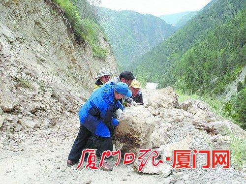 援藏干部下鄉(xiāng)調(diào)研途中遇到滾石墜落，合力將滾石推開為汽車開道。（肖衛(wèi)東 供圖）