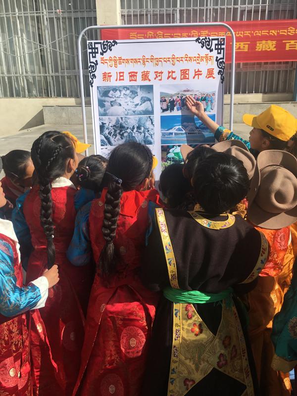 集體活動結束后，各班排隊參觀新舊西藏對比圖片展。圖為五年級的歐珠旺姆和央青措姆擔任解說員，分別為同學們講解新舊西藏圖片。.JPG