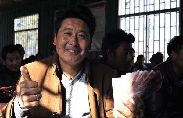 崗巴村一村民領(lǐng)到生態(tài)補(bǔ)償金后，豎起大拇指夸贊黨和國家的生態(tài)環(huán)保政策 本報(bào)記者 麥正偉 攝.jpg