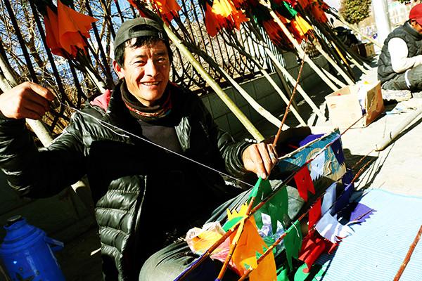 圖為：1月23日上午，來自西藏日喀則市南木林縣農(nóng)民旦增平措，在藏歷火雞新年前來山南縫制、銷售經(jīng)幡樹。他說，每天可以賣出30棵左右，每棵平均賣300元至150元不等，收入可觀。曲杰 攝.jpg